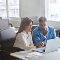 Services informatiques en Suisse romande : deux ingénieurs devant un écran de travail